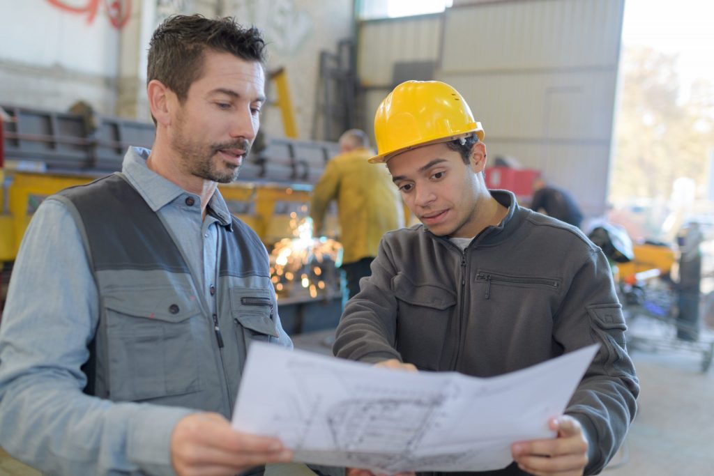  Factory worker and supervisor analyzing plans 